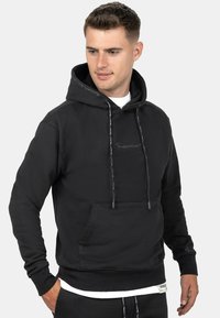 Felpa nera con cappuccio realizzata in tessuto misto cotone, dotata di tasca frontale a marsupio, cordoncino regolabile e dettagli del logo discreti sul cappuccio.