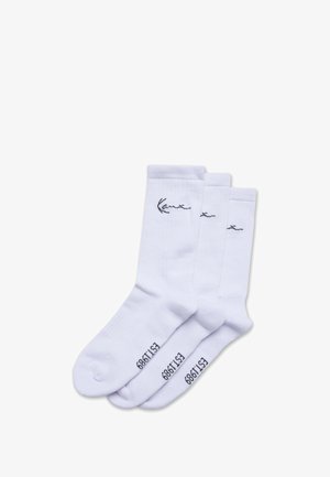 Három pár fehér pamut zokni, bordás felső résszel, sima textúrával és fekete hímzett logóval az oldalán.