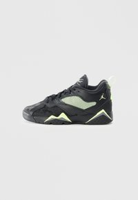 Sneaker atletica nera con una tomaia texturizzata, accenti in rete, dettagli in verde neon e una suola in gomma con motivi geometrici.