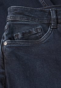 Tmavě modré džíny z denimu s designem pěti kapes, viditelným šitím a malou kapsičkou na mince vpředu. Textura se zdá být hladká.