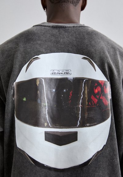 Gray sweatshirt featuring a large graphic of a white racing helmet, showcasing a reflective visor, subtle textures, and printed text detail.