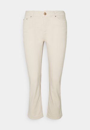 Jean flare beige en coton. Comprend des poches avant, une fermeture par bouton, et des passants pour ceinture. Texture lisse et coupe ajustée.