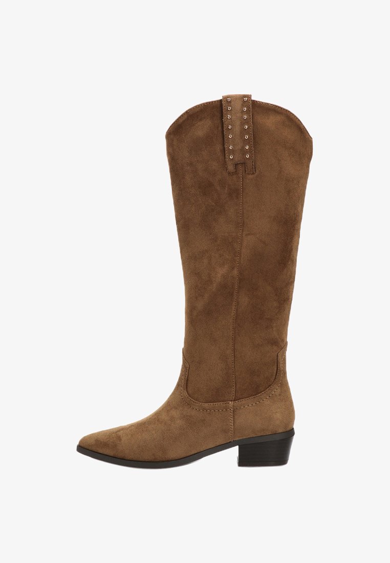Botas marrones de ante sintético hasta la rodilla con punta afilada, tacón bajo y detalles decorativos de tachuelas en la parte trasera. Suela plana y textura suave.