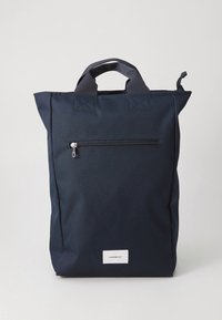 Tamnoplavi najlonski ruksak s teksturiranim završetkom, gornjim ručkama i prednjim džepom sa zatvaračem. Ima pravokutni oblik i minimalni branding.