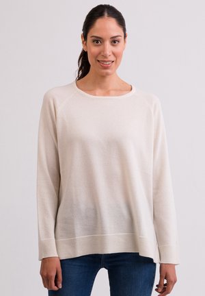 Jasnobeżowy sweter wykonany z miękkiej tkaniny, z okrągłym dekoltem, długimi rękawami i ribbanym wykończeniem. Prezentuje luźny krój.