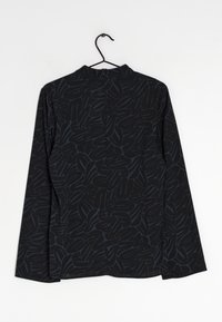 Chemise noire à manches longues avec un motif sombre subtil, col montant et fermeture éclair à l'arrière, confectionnée dans un tissu lisse et léger.