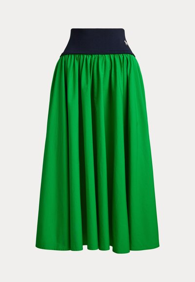 Πράσινη midi φούστα από ελαφρύ ύφασμα με σχεδιασμό ραμμένο, διαθέτει ναυτικό μπλε ζωνάρι στη μέση και διακριτική λεπτομέρεια λογότυπου κοντά στην κορυφή.
