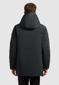 Sort, polstret parka med en stor hætte, lige skæring og glat tekstur. Har minimalistisk design og subtil branding ved halsen.