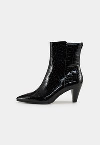 Botín negro hasta el tobillo con punta afilada, fabricado en material sintético de cocodrilo texturizado y brillante, con un tacón de altura media y diseño de fácil puesta.