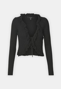 Svart ribbad stickad kofta med långa ärmar, en volangkrage och en knyt-detalj fram. Kort längd med en texturerad finish.