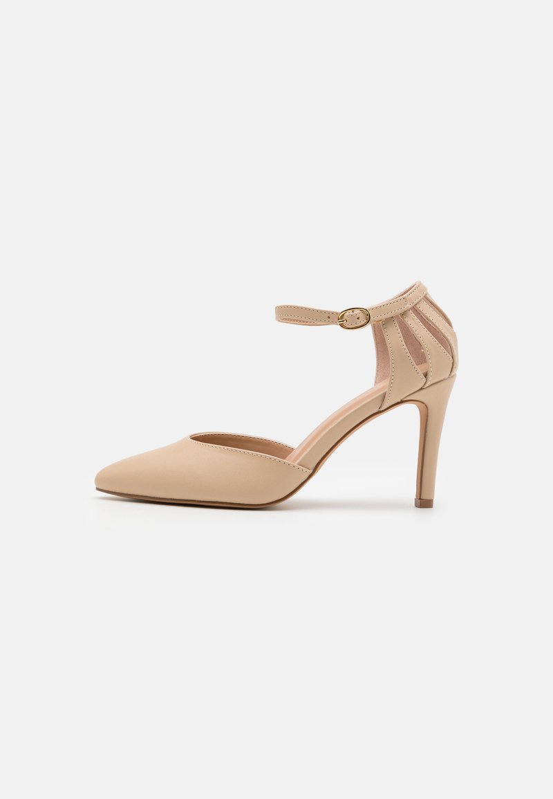 Scarpa con tacco alto in pelle beige, punta affusolata, cinturino alla caviglia e design a taglio sul tallone. Texture liscia con finitura lucida.