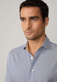 Blue and white striped shirt with a button-down collar; featuring white buttons and a contrasting yellow inner collar detail.