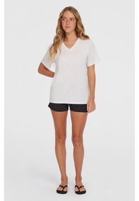 Hvid bomulds V-hals t-shirt kombineret med sorte shorts. T-shirten har korte ærmer og en afslappet pasform, der tilbyder en afslappet stil.