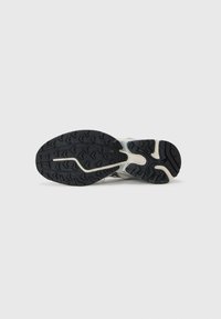 Sport sneaker sole with a black rubber tread pattern, featuring a textured light-colored midsole and a curved design for flexibility.