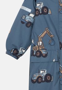 Imperméable bleu pour enfants avec un motif de véhicules de construction. Poignets élastiques et une poche avant pour plus de fonctionnalité.