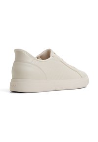 Beżowe sneakersy z plecioną teksturą z boku, górna część z gładkiej skóry, zaokrąglony czubek i płaska gumowa podeszwa. Logo "ALDO" z tyłu.