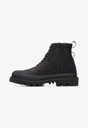 Black ankle boot with textured upper, lace-up front and zip closure, featuring a thick, rugged sole. Suitable for casual or outdoor wear.