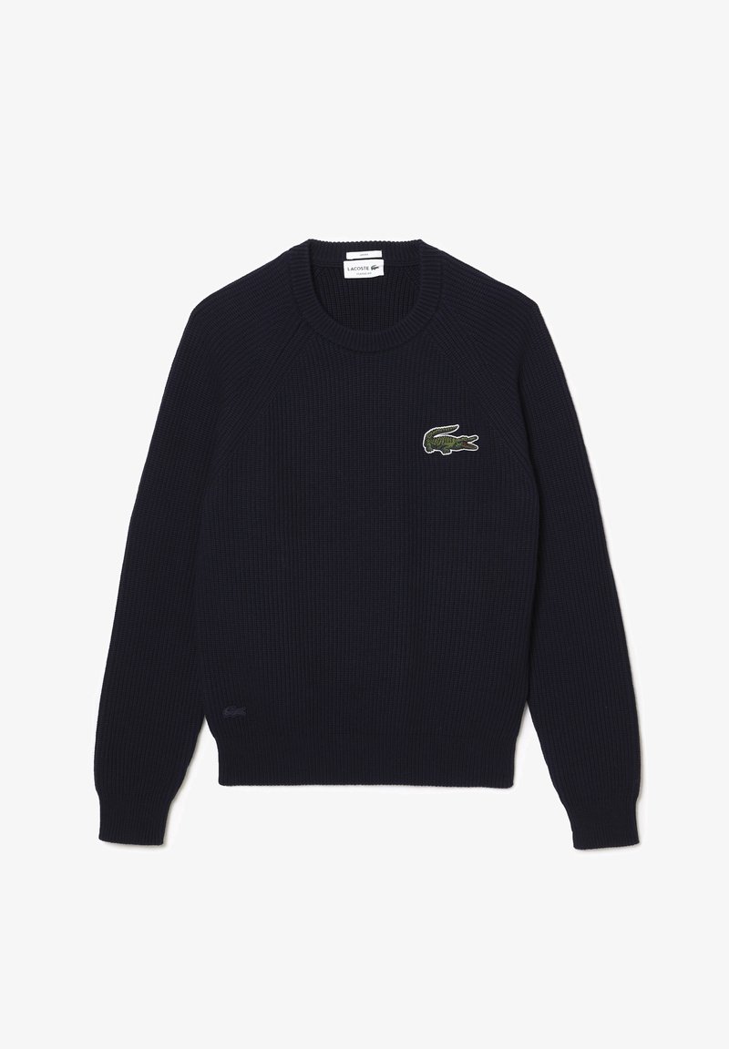 Marineblå ribstrikket sweater med rund halsudskæring, lange raglanærmer og broderet grønt krokodillelogo på brystet.