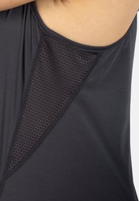Czarna sportowa koszulka na ramiączkach z teksturowanym panelem z siateczki po bokach, gładkim materiałem i okrągłym dekoltem.