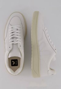 Hvide lædersneakers med lavt design, rund tå og kridhvide såler. Markant "V" logo og stikninger.