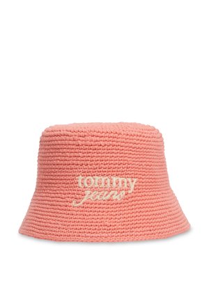 Sombrero estilo pescador tejido de color rosa coral con el logo "tommy jeans" bordado en blanco en la parte delantera, mostrado sobre un fondo blanco.