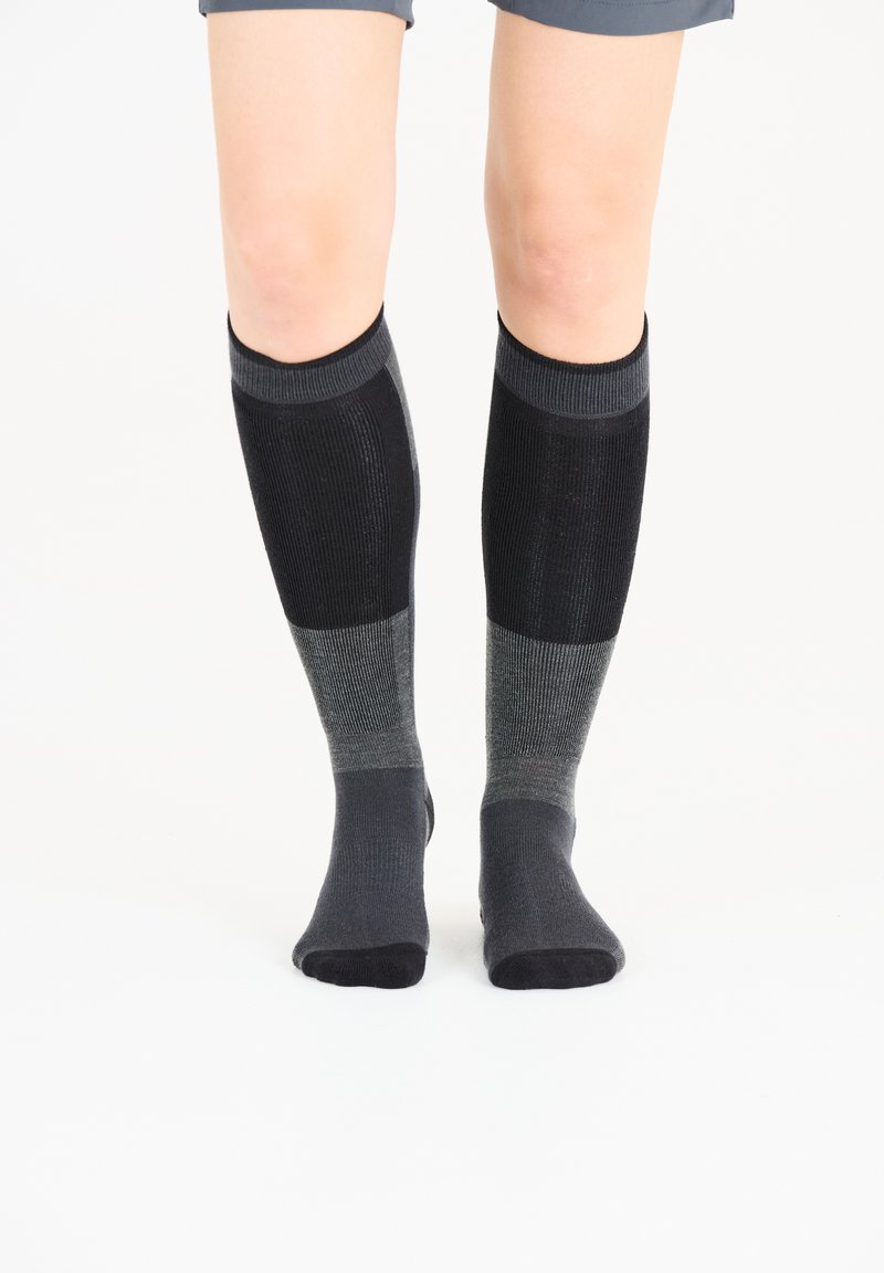 Knä-höga strumpor i olika nyanser av svart och grått, med ribbat mönster och släta detaljer. Mjuk material och åtsittande passform.