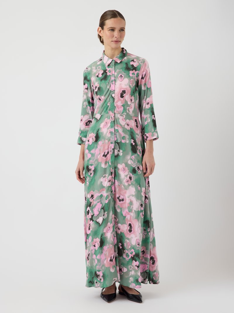 Rochie maxi dintr-un material ușor, cu o bază verde și modele florale mari roz, cu închidere frontală cu nasturi și mâneci până la trei sferturi.