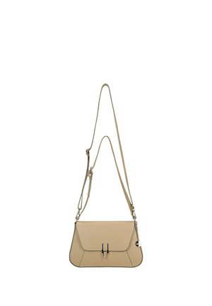 Sac bandoulière en cuir beige avec une sangle ajustable, un rabat avant, une fermeture argentée et un petit pendentif en forme de cœur sur le côté.