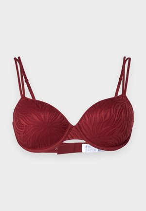 Soutien-gorge bordeaux avec des bonnets moulés et un motif floral texturé. Il dispose de bretelles réglables et d'une fermeture à crochet et à œillet au dos.