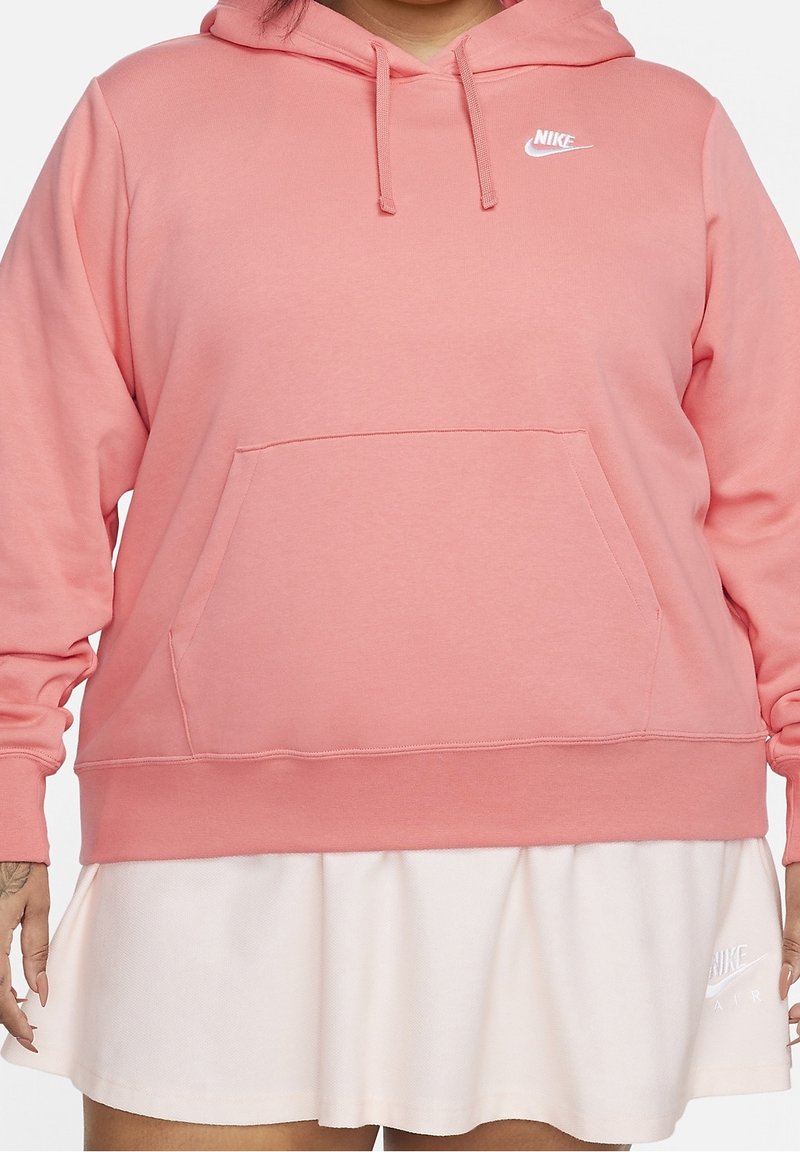 Rosa Nike-hoodie med en framficka, dragsko i huvan och vit logotyp. Tyget verkar mjukt med en slät struktur.