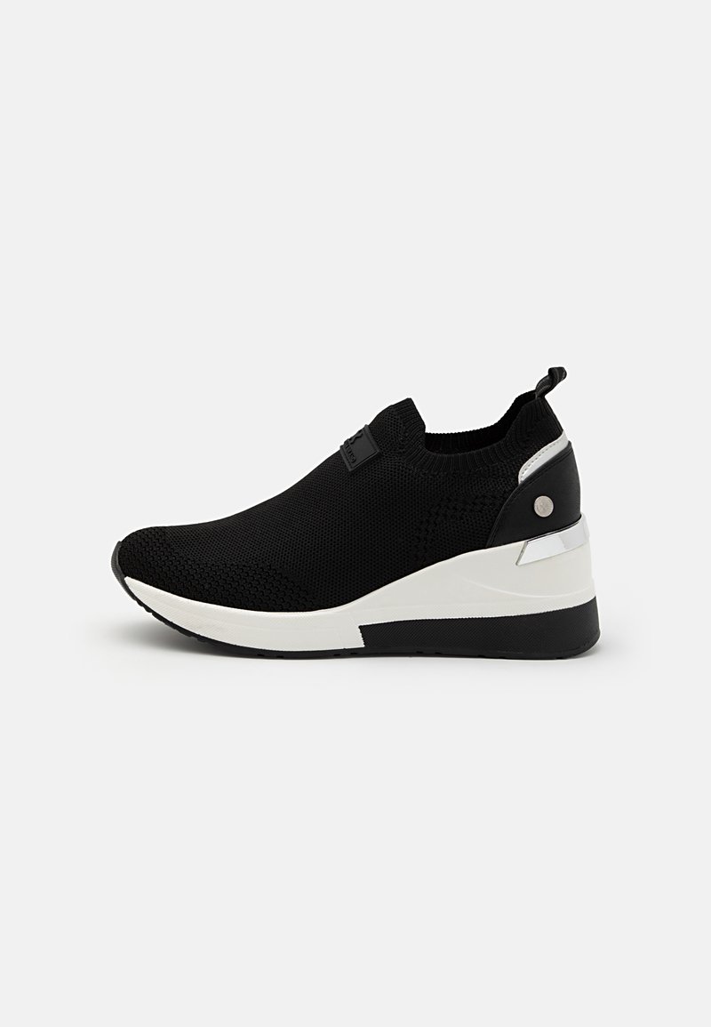Scarpe sportive in maglia nera con suola a cuneo bianco e nero, dotate di un taschino sul tallone e una morbida accentuazione laterale a contrasto.