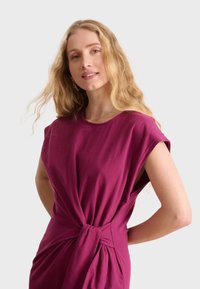 Burgundy cotton dress with cap sleeves, knotted waist detail, and a relaxed fit, featuring soft texture and a smooth finish.