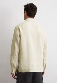 Lichtgele, langemouw blouse van linnen, met een relaxte pasvorm, knoopmanchetten en een rechte zoom. Geen zichtbare patronen of accenten.