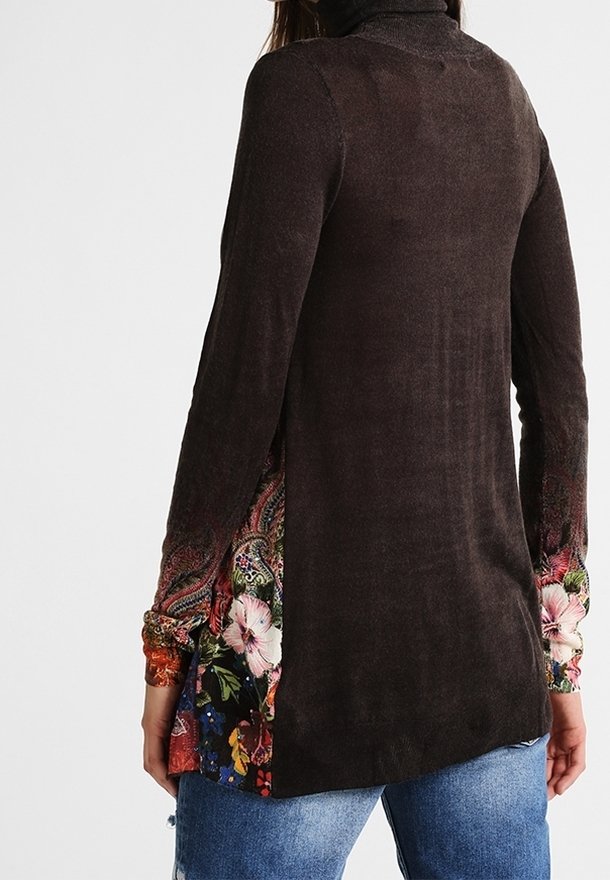 Femme portant un haut à manches longues marron foncé avec des poignets et des côtés à motifs floraux, associée à un jean bleu, vue de dos.