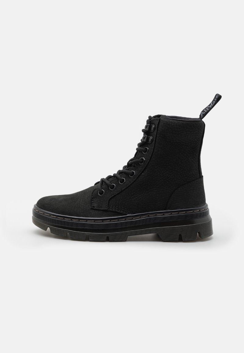 Bottes noires à lacets montant à la cheville, fabriquées en matière texturée, dotées d'une semelle épaisse, de coutures sur le côté et d'une languette à l'arrière du talon.
