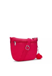 Borsa a spalla di stoffa rosa con cerniera, tracolla regolabile e charm a pom-pom. Texture liscia e forma arrotondata con finiture in hardware argentato.