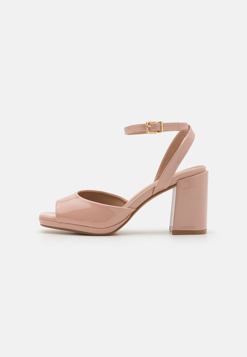 Pink patent leather heeled sandals with an open toe, adjustable ankle strap, and a chunky block heel. Smooth surface and sleek design.