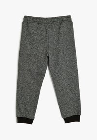 Gray sweatpants with a textured finish, elastic waistband, and black ribbed cuffs at the ankles. Basic, tapered design for comfort.