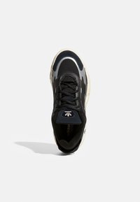 Black athletic shoe with mesh and synthetic materials, featuring a rounded toe, laces, and three black stripes on the side. Accents in grey.