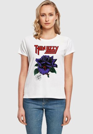 Bílý krátký rukáv tričko s velkým fialovým růžovým grafickým motivem a červeným textem "Thin Lizzy". Volný střih s jemnou bavlněnou texturou.