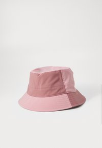 Bucket hat with a two-tone design, featuring a soft pink top and a deeper pink bottom. Made from lightweight fabric with visible stitching details.
