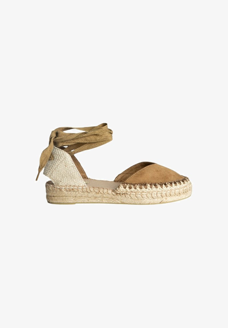 Sandalia espadrille en ante marrón y tejido de color beige trenzado. Presenta ataduras en el tobillo y suela de yute trenzado. Punta redondeada y acentos cosidos.