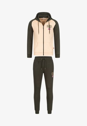 Huppari, jossa on vetoketju, vaaleanbeige ja tumma vihreä, sisältää kaksi etutaskua ja logon yksityiskohtana. Yhteensopivat tumma vihreät collegehousut, joissa on nyöri vyötäröllä.