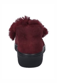 Burgundy ruskind slip-on sko med en blød, fluffy tekstur bagpå og en sort gummisål, med minimalistiske design detaljer.