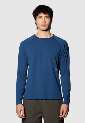 Long-sleeve blue athletic shirt made of textured fabric, featuring a crew neckline and raglan sleeves, with a logo detail near the hem.