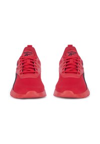 Červené športové topánky s textilným zvrškom, kontrastnými čiernymi akcentmi, polstrovaným golierom a šnúrkami. Majú textúrovanú podrážku pre lepší grip.