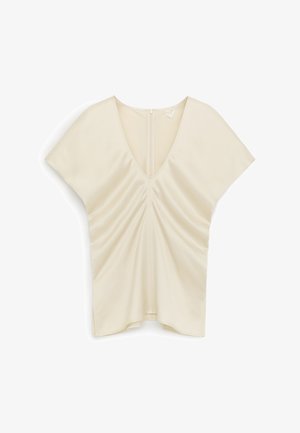 Kremowa bluzka z krótkim rękawem, dekoltem w serek, marszczonym przodem i zapięciem na zamek z tyłu, prezentowana na białym tle.