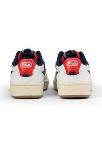 Sneaker in pelle bianca con accenti blu navy e rossi. Presentano un collo imbottito, un logo sul tallone e una suola in gomma.