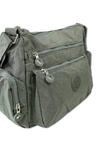 Graue Stoff-Schultertasche mit mehreren Reißverschlusstaschen, runden Beschlägen und einem flachen Boden. Mit einem Logo-Patch auf der Vorderseite.