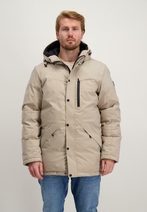 Beige geïsoleerde jas met een capuchon, voorzien van een voorrits, twee zijzakken en een borstzak met zwarte accenten. Glad van textuur.